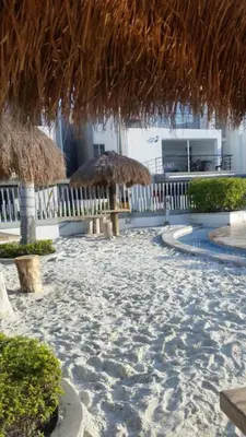 a resort with two straw umbrellas and a beach at SANTAFE APARTASOLES in Santa Fe de Antioquia