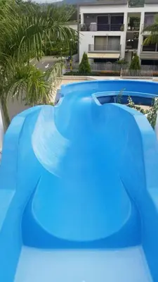 a blue slide in front of a building at SANTAFE APARTASOLES in Santa Fe de Antioquia