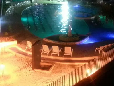 a swimming pool with chairs and a fountain at night at SANTAFE APARTASOLES in Santa Fe de Antioquia