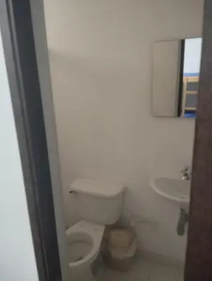 a white bathroom with a toilet and a sink at SANTAFE APARTASOLES in Santa Fe de Antioquia
