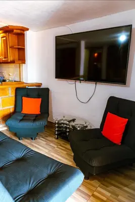 a living room with two chairs and a flat screen tv at Suite Doble in Jericó