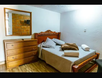 a bedroom with a bed with a dresser and a mirror at Suite Doble in Jericó