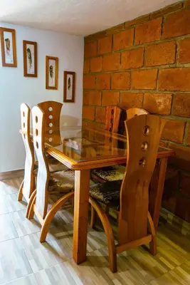 a dining room table with chairs and a brick wall at Suite Doble in Jericó