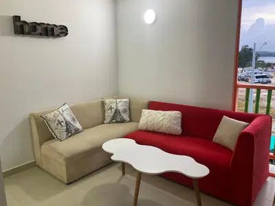 a living room with a red couch and a white table at La Casita De Colores in Guatapé