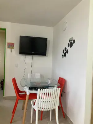 a dining room with a glass table and red chairs at La Casita De Colores in Guatapé