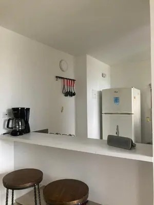 a kitchen with two stools and a white refrigerator at La Casita De Colores in Guatapé