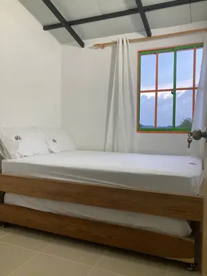 a bed in a room with a window at La Casita De Colores in Guatapé