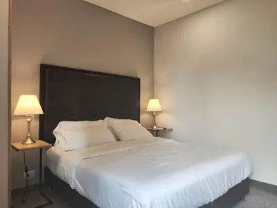 a bedroom with a large white bed with two lamps at Tropical Confort suite Poblado in Medellín
