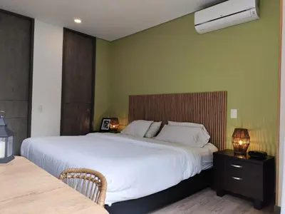 a bedroom with a large white bed and a nightstand at Tropical Confort suite Poblado in Medellín