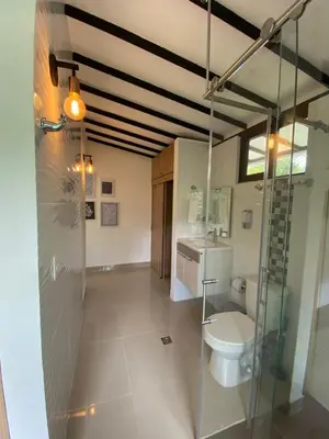 a bathroom with a toilet and a glass shower at CRISTALES DEL RIO RESORT in San Rafael