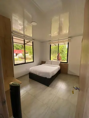a bedroom with a bed and two windows at CRISTALES DEL RIO RESORT in San Rafael