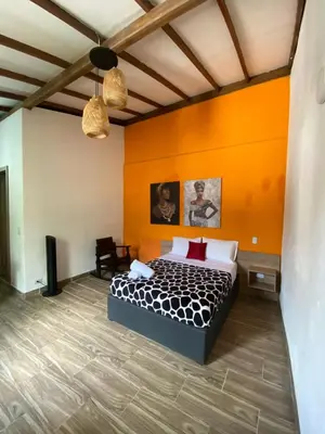 a bedroom with a bed and an orange wall at CRISTALES DEL RIO RESORT in San Rafael