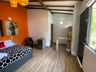 a bedroom with orange walls and a bed and a desk at CRISTALES DEL RIO RESORT in San Rafael