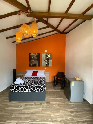 a bedroom with a bed with an orange wall at CRISTALES DEL RIO RESORT in San Rafael