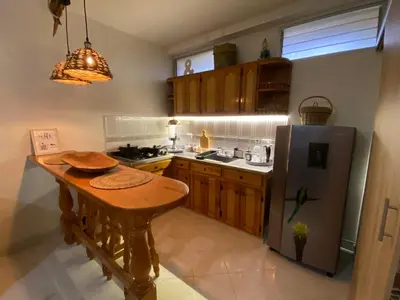 a kitchen with a wooden table and a refrigerator at Casa Magia in Urrao