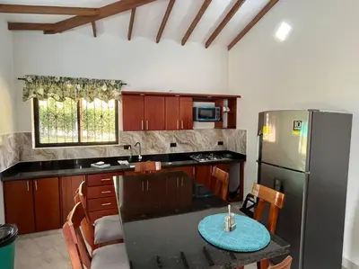 a kitchen with a stainless steel refrigerator and a table at Finca Maribet in Cisneros