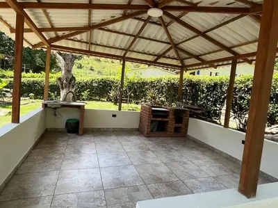 an outdoor patio with a large wooden pergola at Finca Maribet in Cisneros