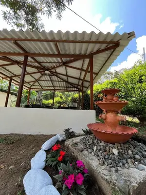a large urn in a garden with a wooden umbrella at Finca Maribet in Cisneros