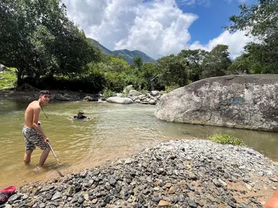 a man standing in the water with a stick at Finca Maribet in Cisneros