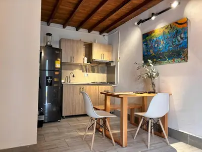 a kitchen with a table and chairs and a refrigerator at ApartaLoft Carolina in Carolina del Principe