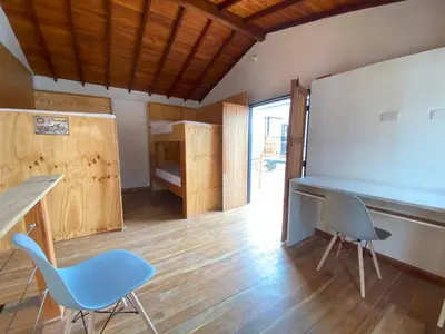 a classroom with two chairs and a desk and a bed at ApartaLoft Carolina in Carolina del Principe