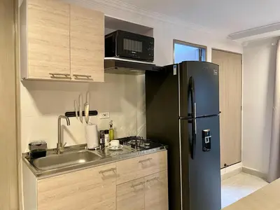 a kitchen with a black refrigerator and a sink at Apartments with Jacuzzi in El Poblado by Wynwood House in Medellín