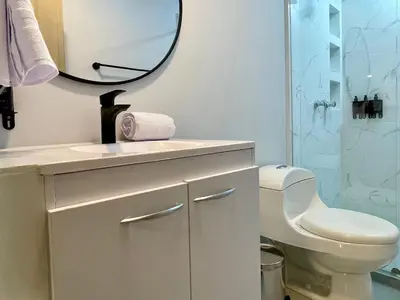 a bathroom with a sink and a toilet and a mirror at Apartments with Jacuzzi in El Poblado by Wynwood House in Medellín