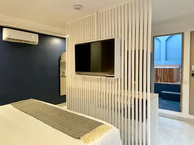 a bedroom with a tv on a wall at Apartments with Jacuzzi in El Poblado by Wynwood House in Medellín