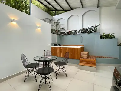 a room with a table and chairs and plants at Apartments with Jacuzzi in El Poblado by Wynwood House in Medellín