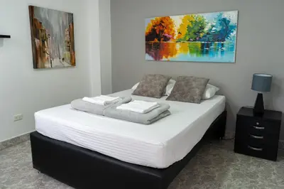 a bedroom with a bed with white sheets and pillows at Apartamento Parque de Guatapé in Guatapé