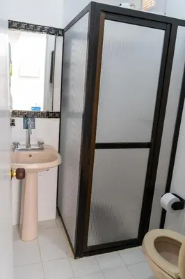 a bathroom with a shower with a sink and a toilet at Apartamento Parque de Guatapé in Guatapé