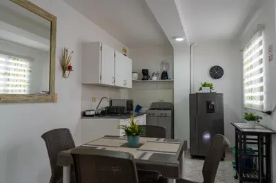 a kitchen with a table with chairs and a refrigerator at Apartamento Parque de Guatapé in Guatapé