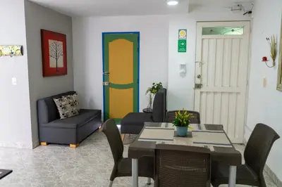 a dining room with a table and chairs and a door at Apartamento Parque de Guatapé in Guatapé