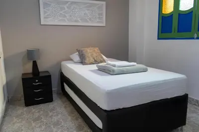 a small bedroom with a bed and a night stand at Apartamento Parque de Guatapé in Guatapé
