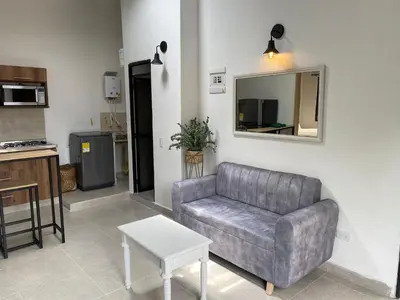 a living room with a couch and a mirror at Hermoso Apartamento en Medellín in Medellín
