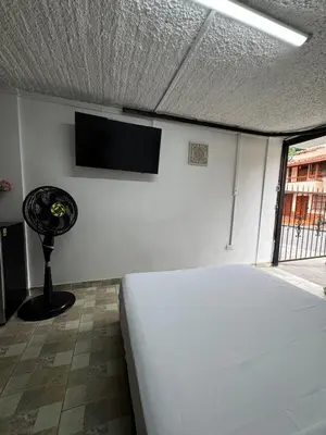 a bedroom with a bed and a tv on the wall at Hermoso apartamento cerca al Poblado in Medellín
