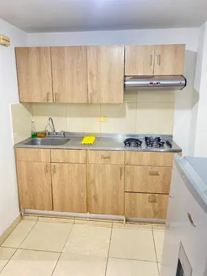 a kitchen with wooden cabinets and a sink at Hermoso apartamento cerca al Poblado in Medellín