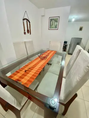 a glass table in a living room with white chairs at Hermoso apartamento cerca al Poblado in Medellín
