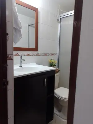 a bathroom with a sink and a toilet and a mirror at Hermoso apartamento cerca al Poblado in Medellín