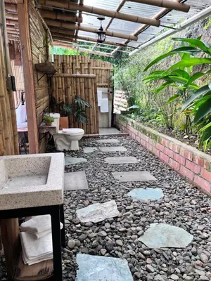 a bathroom with a sink and a toilet on a pebble floor at Zioru cabaña in Belalcázar