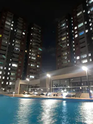 a pool with cars parked in front of buildings at night at Habitación Masculina 1 persona en Apartamento Compartido Medellín in Medellín