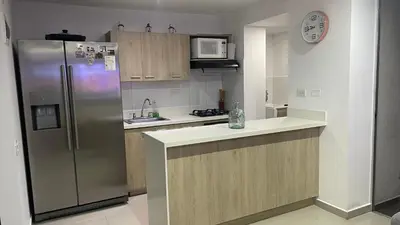 a kitchen with a stainless steel refrigerator and wooden cabinets at Habitación Masculina 1 persona en Apartamento Compartido Medellín in Medellín