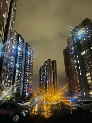 a city at night with cars parked in front of tall buildings at Habitación Masculina 1 persona en Apartamento Compartido Medellín in Medellín