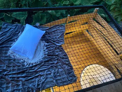 a bird cage with a blue pillow on it at Turmequé cabaña in Alto de la Mina