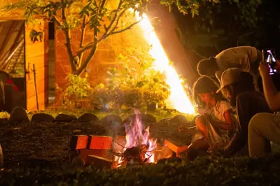 a group of people sitting around a fire at Turmequé cabaña in Alto de la Mina