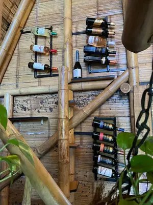 a bunch of wine bottles hanging on a wall at Turmequé cabaña in Alto de la Mina