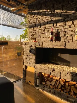 a stone wall with a fireplace in a room at Turmequé cabaña in Alto de la Mina