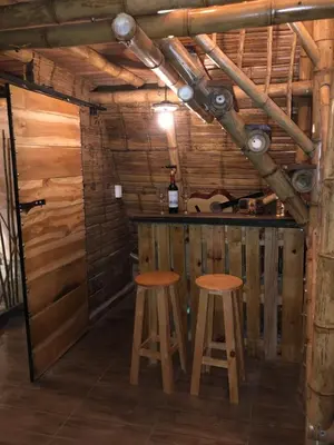 a bar in a wooden cabin with two stools at Turmequé cabaña in Alto de la Mina