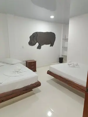a room with two beds and a bear on the wall at Hotel vacation Doradal in Doradal