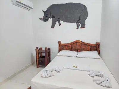 a bedroom with a bed with a painting of a rhino on the wall at Hotel vacation Doradal in Doradal